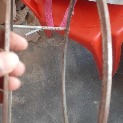 Rare Machinery rusted circular metal rings spare part held by hand on concrete floor rice mill grinder frame for sale